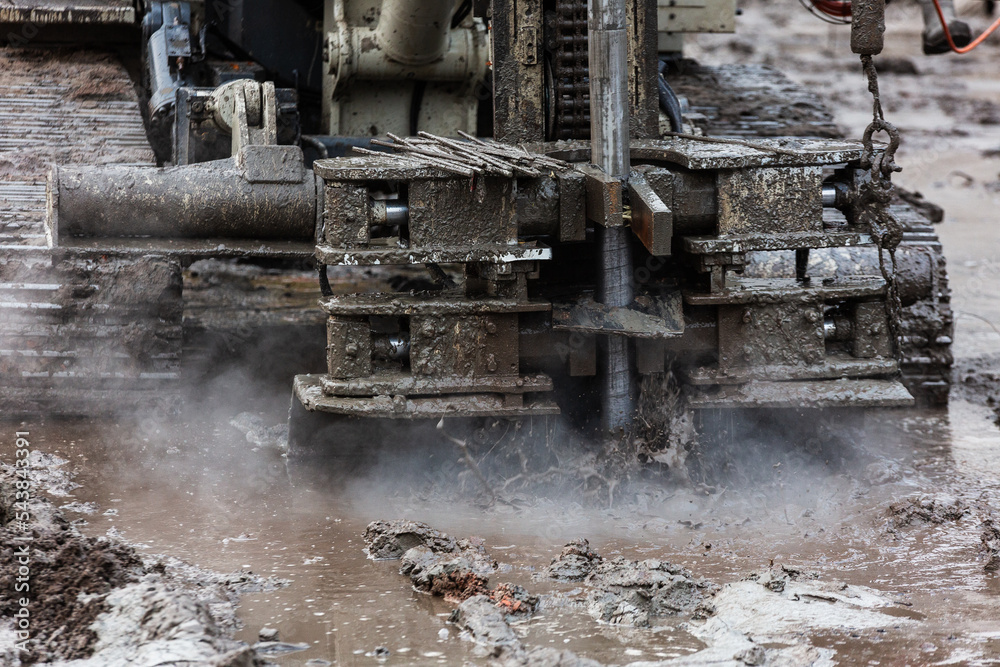 Drilling rig with splashes of mud and steam.