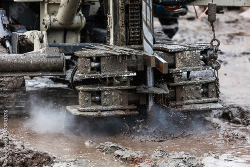 Drilling rig with splashes of mud and steam.