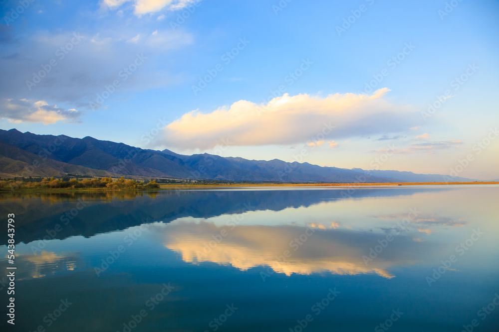 Fototapeta premium Lake in the mountains. Beautiful nature, reflection of clouds and mountains in blue water. Kyrgyzstan, Lake Issyk-Kul