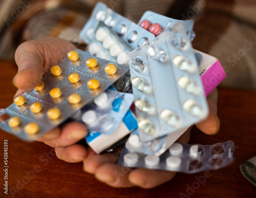 many different pills and medicines in the hands of an old man photo