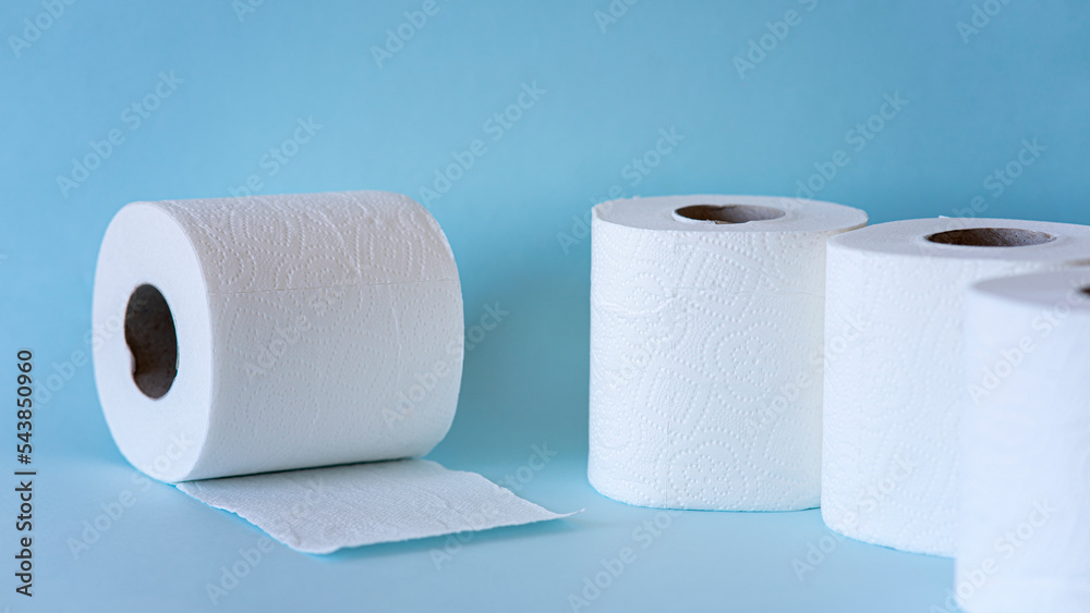 White toilet paper rolls on the blue background. Hygiene concept. White toilet paper rolls on the blue background. Hygiene concept.