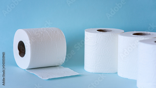 White toilet paper rolls on the blue background. Hygiene concept.