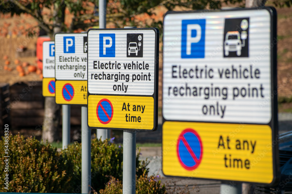 Electric vehicle charging point signs. A row of EV charging point information boards in a line. Selective focus on the second plate along. New Energy Vehicle charging and infrastructure. Range anxiety
