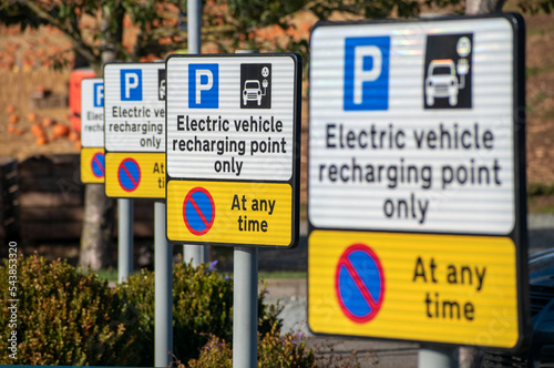 Electric vehicle charging point signs. A row of EV charging point information boards in a line. Selective focus on the second plate along. New Energy Vehicle charging and infrastructure. Range anxiety