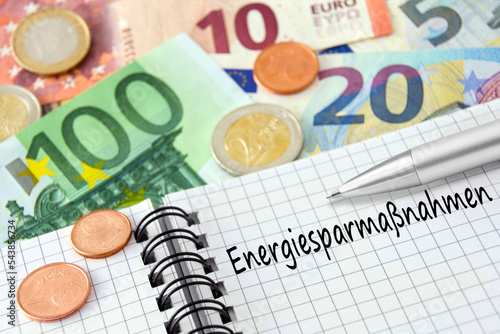 Finanzen und Energiesparmaßnahmen mit Buch und Euro Geldscheinen photo