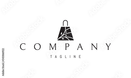 Vector logo on which an abstract image of a package with handles with a silhouette of a tree on it.