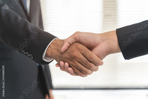 two business people shaking hands after contract is done.