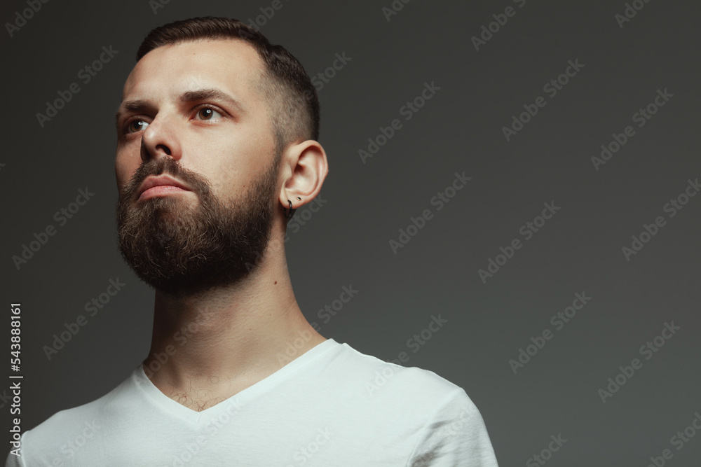Male beauty concept. Portrait of proud charismatic active 30-year-old man posing over dark gray background. Perfect haircut. Hipster style. Close up. Copy-space. Studio shot Male beauty concept. Portrait of proud charismatic active 30-year-old man posing over dark gray background. Perfect haircut. Hipster style. Close up. Copy-space. Studio shot