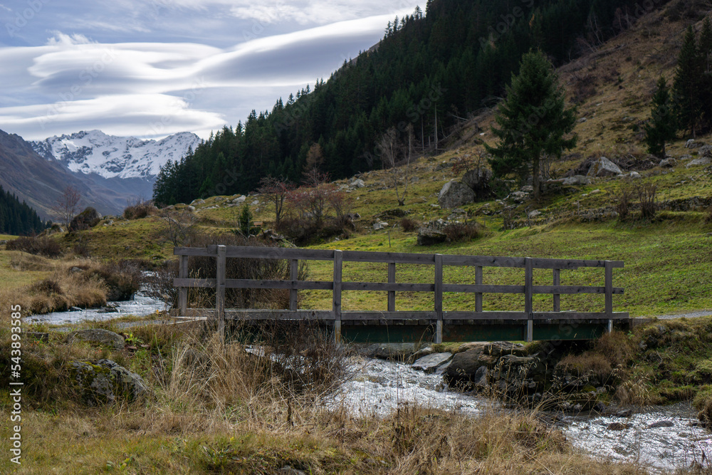 Wooden old bridge across the stream in Switzerland Alps Wooden old bridge across the stream in Switzerland Alps