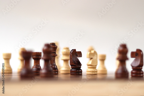 A chessboard with walking figures placed on a white background. Strategy game.