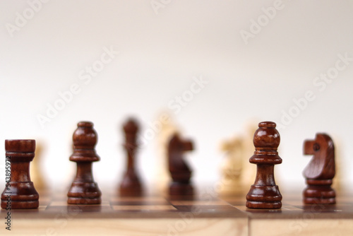 A chessboard with walking figures placed on a white background. Strategy game.