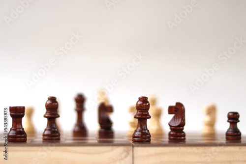 A chessboard with walking figures placed on a white background. Strategy game.
