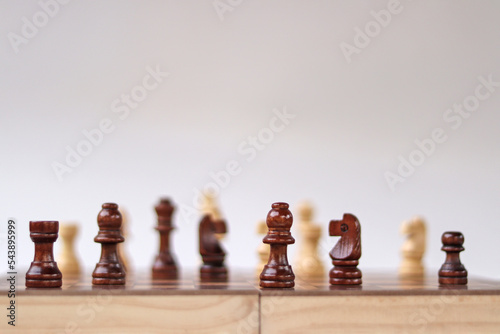 A chessboard with walking figures placed on a white background. Strategy game.