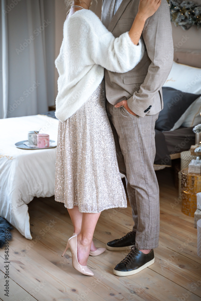 Obraz premium Romantic couple standing near Christmas tree at home and hugging