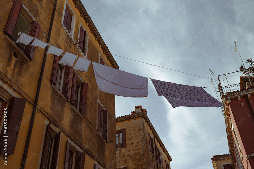 Street in Venice with washing hung out to dry in the sun over the water channel Street in Venice with washing hung out to dry in the sun over the water channel