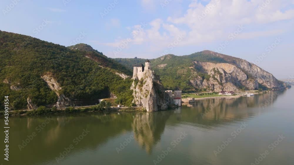 Aerial video of Golubac medieval fortress located on the Danube river on Serbian bank. Footage was shot from a drone at higher altitude with camera level for a panoramic shot of the river and fort. Aerial video of Golubac medieval fortress located on the Danube river on Serbian bank. Footage was shot from a drone at higher altitude with camera level for a panoramic shot of the river and fort.