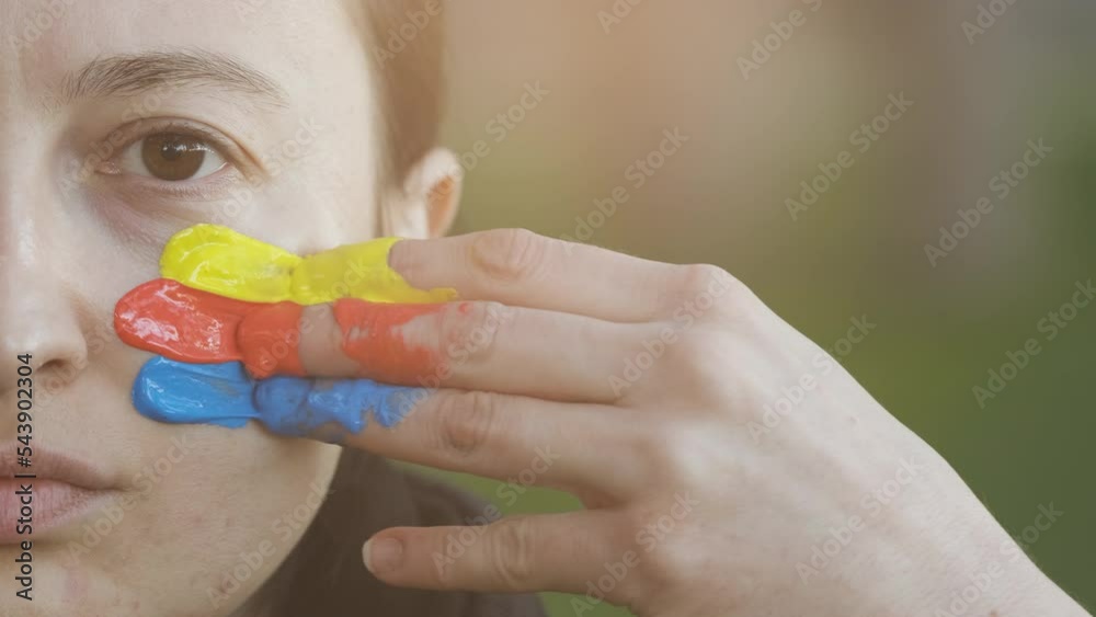 Supporter Painting Face and Looking at Camera. Football Fan Preparing for the Match. Colored Face with Flag Colors Yellow, Blue and Red. Slow Motion 4K Prores 422