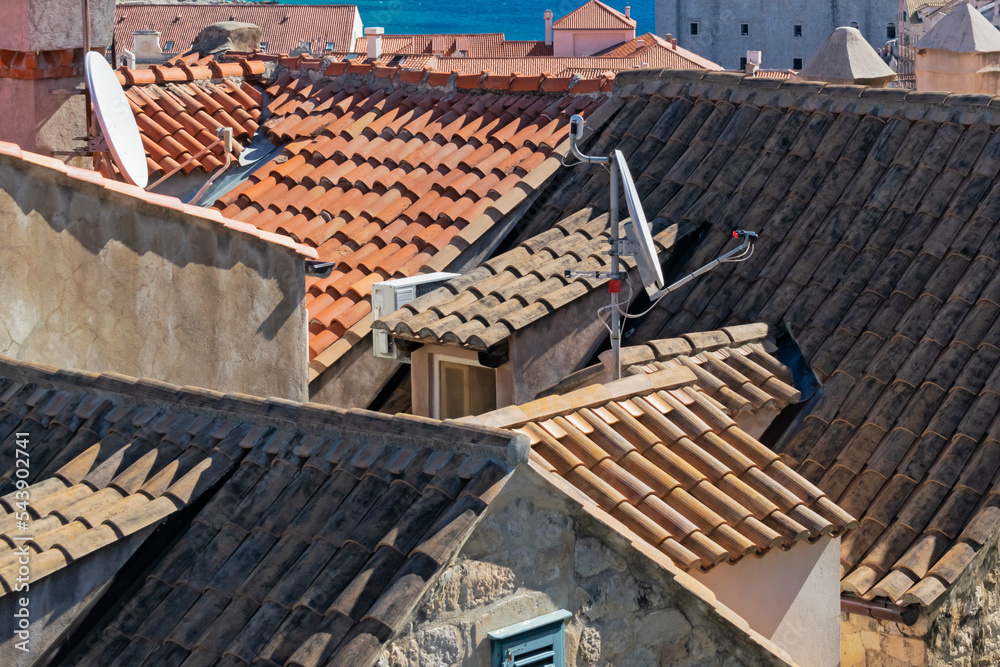 Details of walls, roof tiles and windows of yellow, orange and brown houses as seen in sunny day in Dubrovnik, Croatia. September, sunset. Abstract vintage or travel or architecture background.