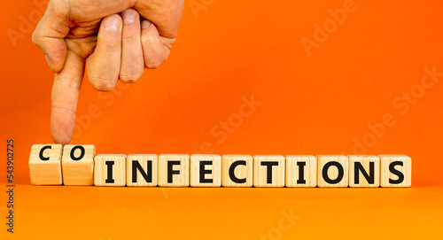 Coinfections or infections symbol. Concept words Coinfections and Infections on wooden cubes. Doctor hand. Beautiful orange background. Medical coinfections or infections concept. Copy space. photo