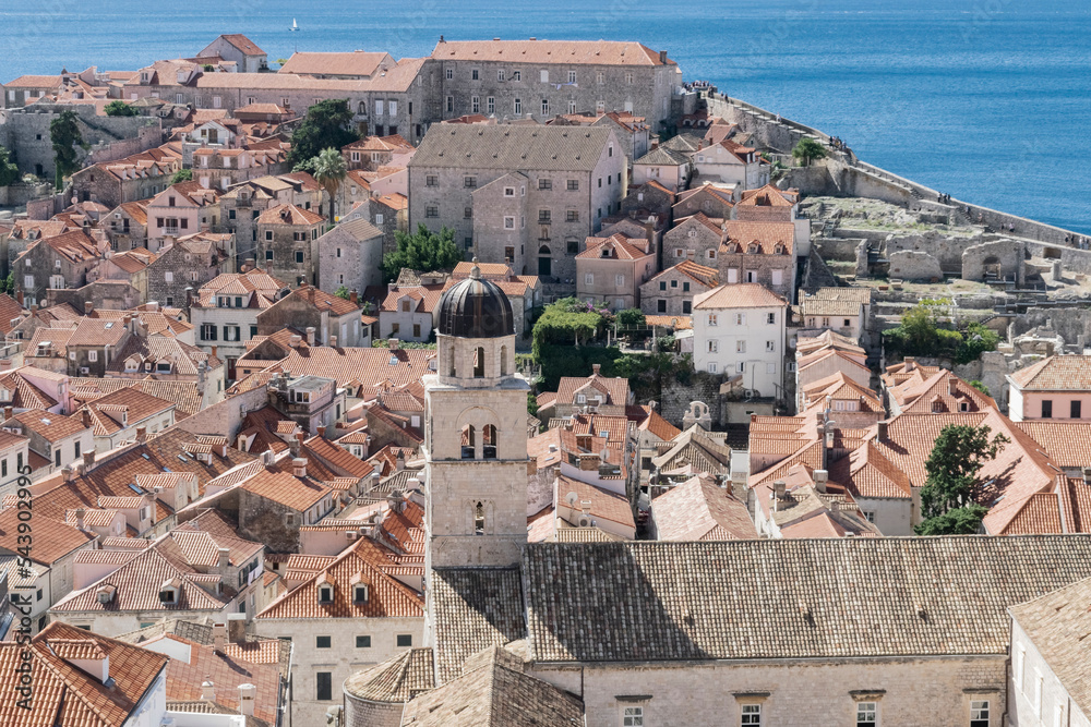 Aerial skyline panoramic view of Dubrovnik old town at sunset featuring brown, orange and yellow roofs. Vintage or holiday travel background. Dubrovnik, Croatia. 