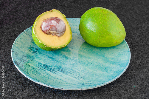 A fruta abacate representada natural e cortada, de excelentes propriedades que ajudam na saúde e bem-estar das pessoas photo