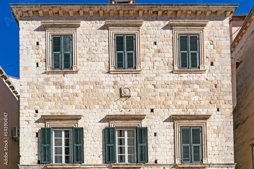 Details of walls and windows of yellow, orange and brown houses as seen in sunny day in Dubrovnik, Croatia. September, daytime. Abstract vintage or travel background.