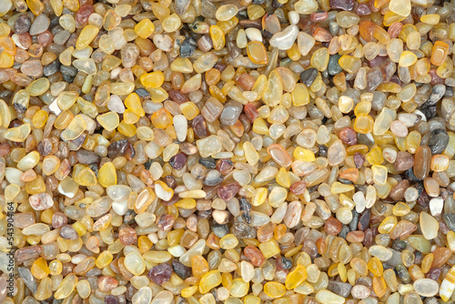 Full frame of Yellow Agate gemstone particles. Decorative Stone pebbles for coating in the Aquarium or garden. Extreme close up of heap, top view