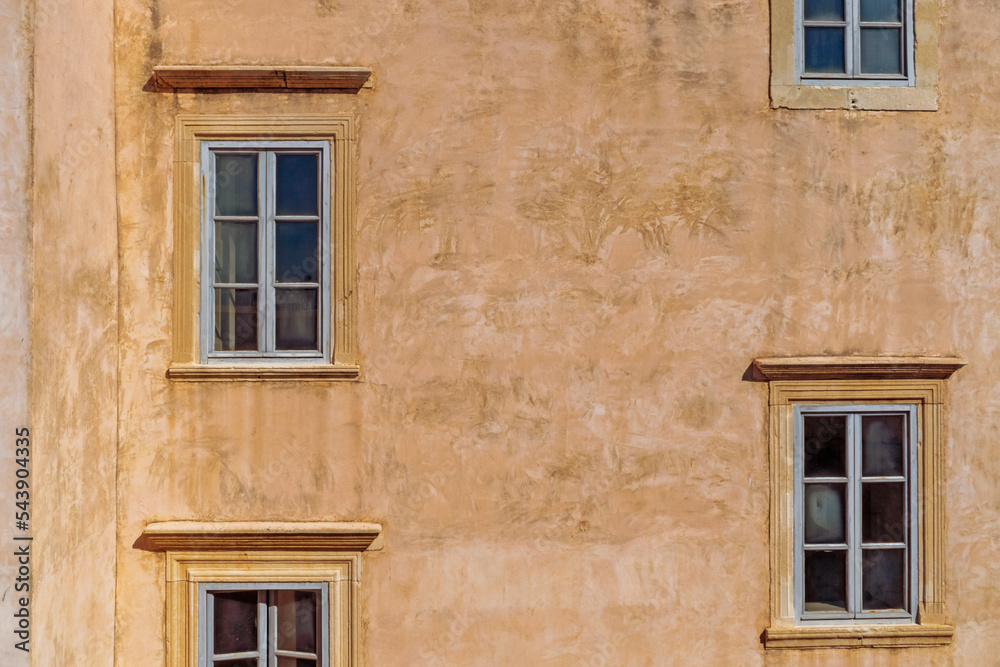Details of walls and windows of yellow, orange and brown houses as seen in sunny day in Dubrovnik, Croatia. September, daytime. Abstract vintage or travel background.