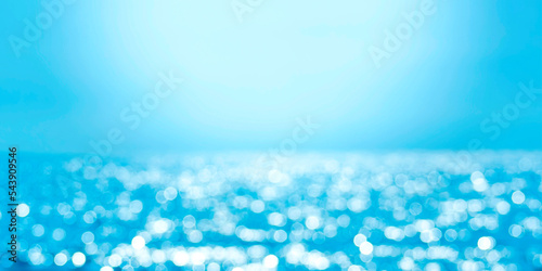 Delicate blue texture bokeh sea. Summer background. Blurry blue bokeh glare on the water on a sunny day. Banner concept travel.
