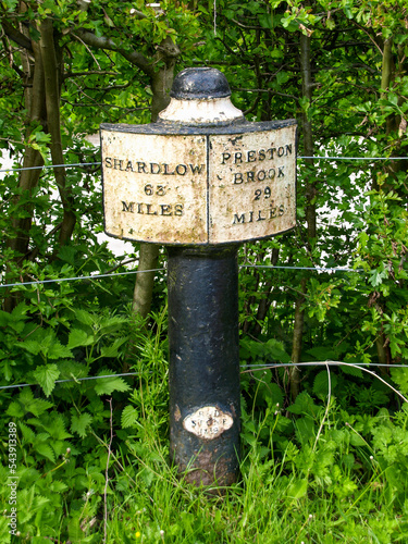 Cast iron signpost on the Trent and Mersey Canal near Stoke-on-Trent in England showing the distance to Shardlow and Preston Brook.