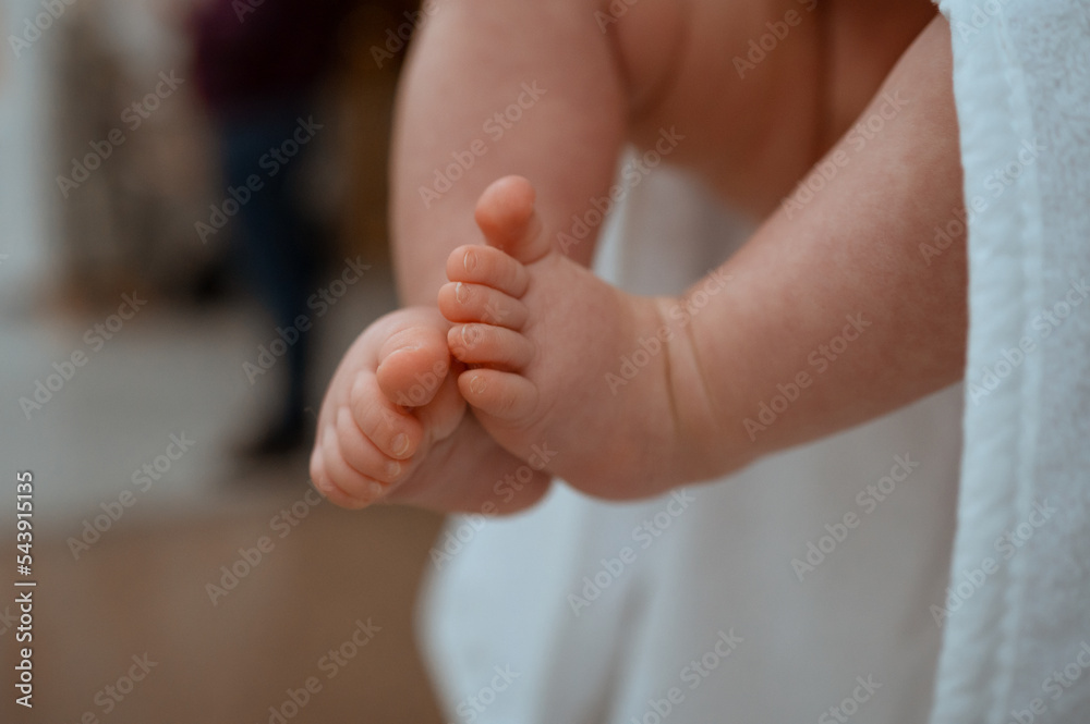 small children's legs close-up in mom's hands small children's legs close-up in mom's hands