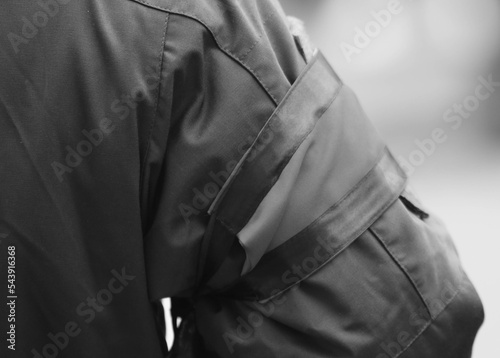 A soldier in a warm uniform with a red mourning band