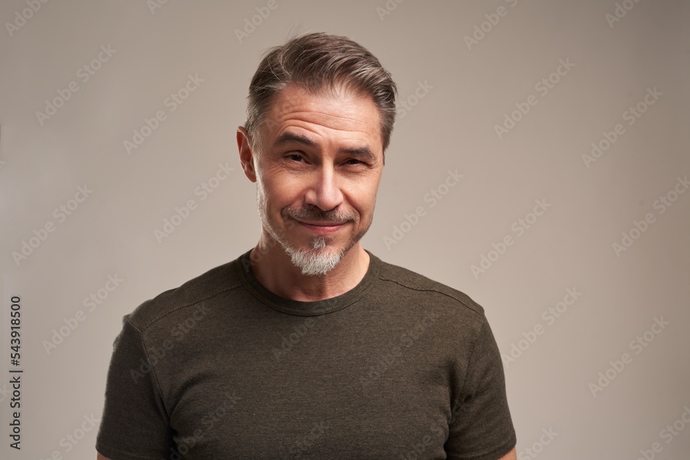 Obraz premium Portrait of handsome man standing on white grey background, looking at camera.