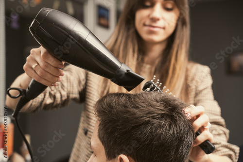 Foto Hair salon master blow dry hair client at barber shop