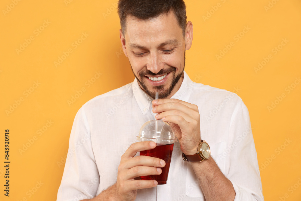 Man drinking delicious juice on orange background Man drinking delicious juice on orange background