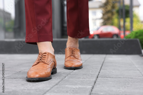 Woman in red pants and fashionable shoes walking on city street, closeup. Space for text