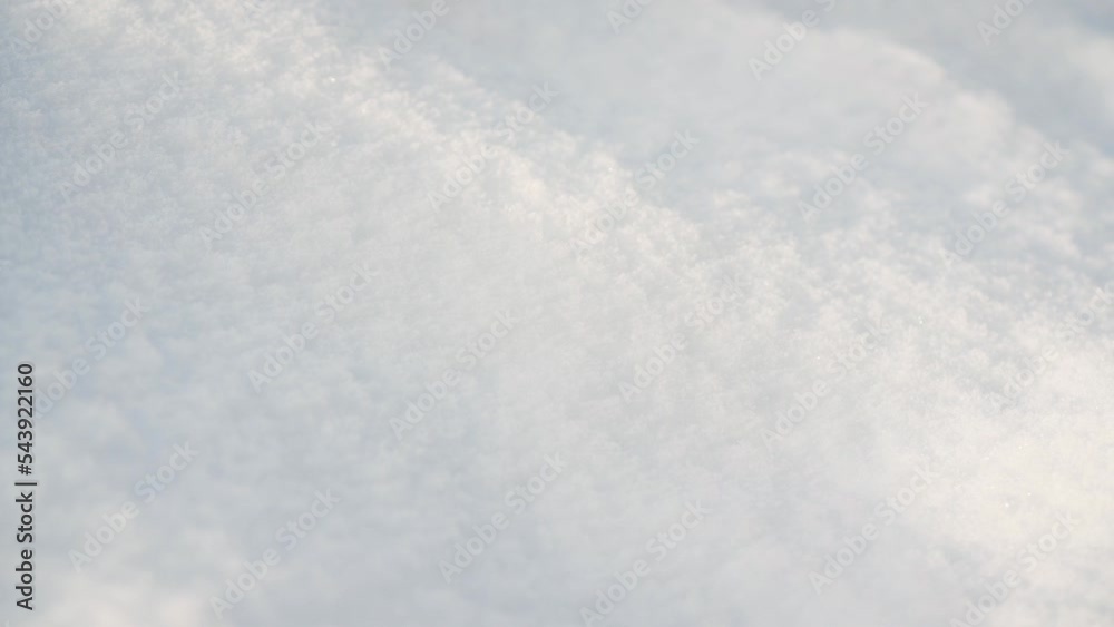 Sun shines on ground covered with snow forming small hills - closeup macro detail, camera moves to side Sun shines on ground covered with snow forming small hills - closeup macro detail, camera moves to side