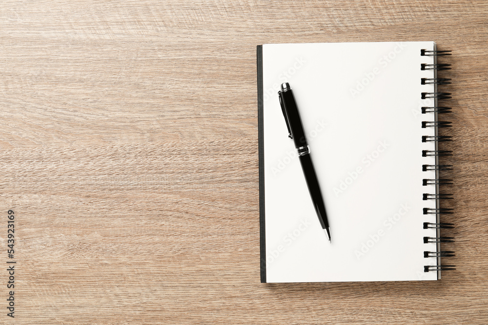 Notebook and pen on wooden table, top view. Space for text Notebook and pen on wooden table, top view. Space for text