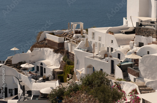 Oia, Santorini, Greece. 2022. Cliffside accommodations facing the Agean sea at Oia on Santorini island, rooms, apartments, rental, Greece. photo