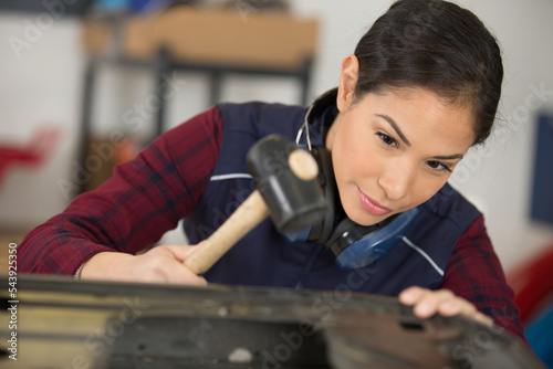 young woman working with hammer in industrial building