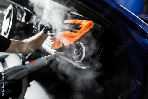 Steam cleaning of car air system. Worker in auto cleaning service clean car inside. Car interior detailing.