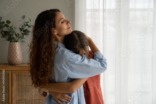Fotografie Young caring woman hugging teenage girl needing support after school troubles