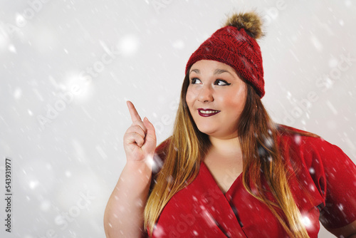 Plus size christmas woman pointing at copy space