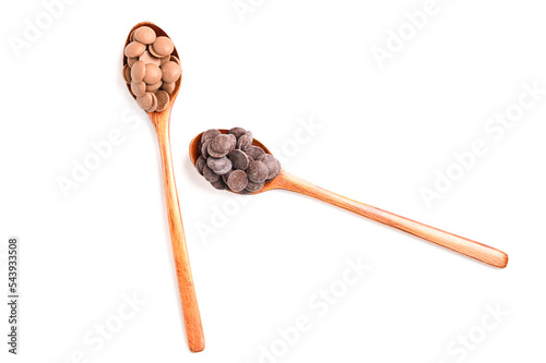 Close up of two types of couverture chocolate. Chocolate callets in wooden spoon isolated on white.