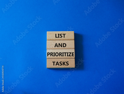 List and prioritize tasks symbol. Concept words List and prioritize tasks on wooden blocks. Beautiful blue background. Business and List and prioritize tasks concept. Copy space.