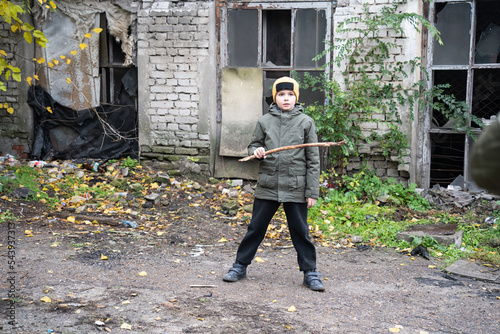 a teenager defends himself with a stick in his hands on an abandoned street