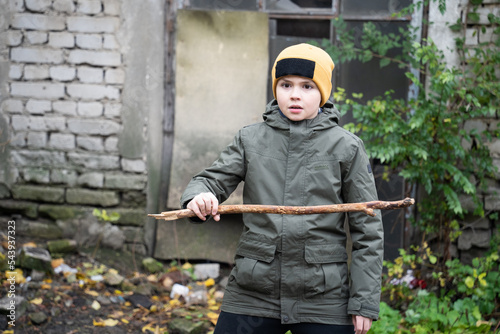 a teenager defends himself with a stick in his hands on an abandoned street