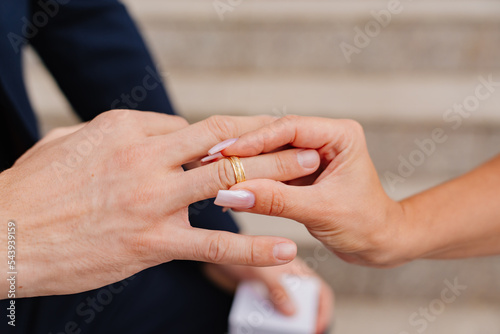 close up. hands of a groom and a bride and they exchange rings.