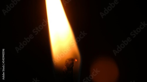 Eine Kerzenflamme mit Docht vor dunklem Hintergrund, Makroaufnahme