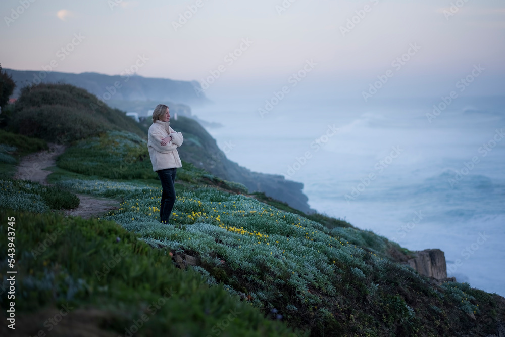A woman greets the sunrise on the Atlantic coast.